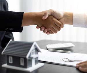 Mortgage Buydown home buyer and sellers handshake over loan papers
